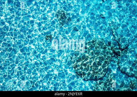 Textured backdrop of turquoise colored clear rippling water surface on Cala Turqueta beach Stock Photo