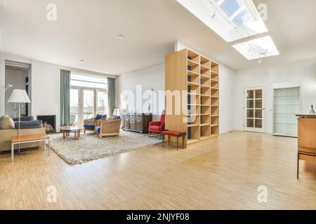 Interior design of modern spacious living room with sofa placed against armchairs and coffee table on soft carpet near fireplace and big wooden empty Stock Photo