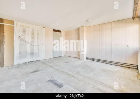 Interior design of light spacious room with new beige wallpapers on old walls and concrete floor Stock Photo