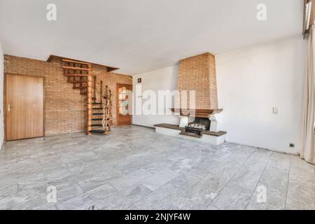 Interior design of house in traditional style with round narrow stairway with wooden railing and rope against brick wall on gray floor tile near doors Stock Photo