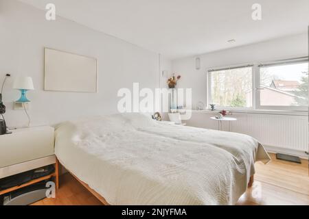 Interior of modern stylish bedroom with soft bed under white blanket placed against windows Stock Photo