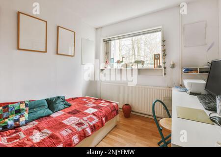 Interior design of light bedroom with bed and laptop placed on table near window Stock Photo