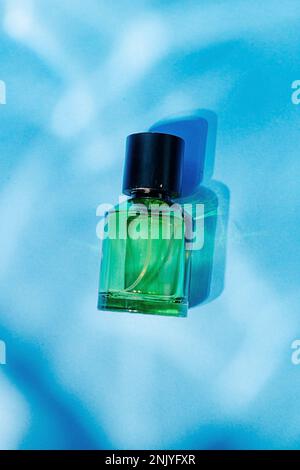 Green glass transparent empty container placed on blue background Stock Photo