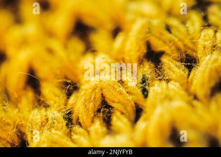 Closeup full frame background of bright yellow knitted sweater with soft yarn texture Stock Photo