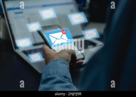 Businessman using mobile and Laptop computer internet with email icon, email marketing concept, send e-mail or news letter, online working internet ne Stock Photo
