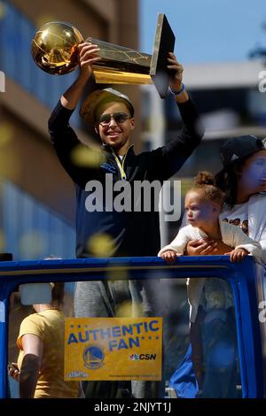 Golden State Warriors' Stephen Curry gestures while holding the Larry O'Brien  trophy during a parade and rally after winning the NBA basketball  championship, in Oakland, Calif. (AP Photo/Marcio Jo …