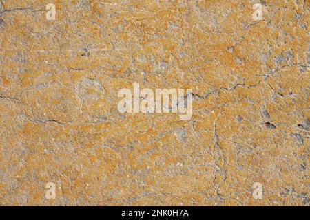 Grunge yellow orange brown old painted concrete or stone wall background texture with stains of faded paint peel and scaling, uneven and weathered Stock Photo
