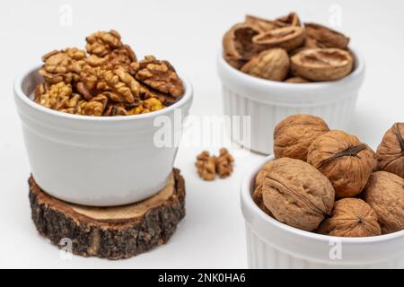 Nuts, shells and nut kernels in white bowls. Close up. Top view. White background Stock Photo