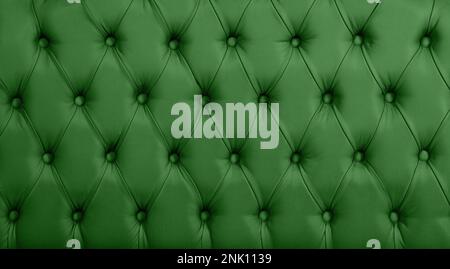 Close up background texture of dark green capitone genuine leather, retro Chesterfield style soft tufted furniture upholstery with deep diamond patter Stock Photo
