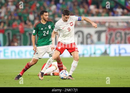 Luis Chavez of Mexico (L) and Robert Lewandowski of Poland (R) in action during the FIFA World Cup Qatar 2022 Match between Mexico and Poland at Stadium 974. Final score: Mexico 0:0 Poland. Stock Photo