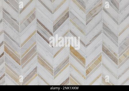White, gray and brown marble herrinbone tile on a bathroom wall or kitchen backsplash Stock Photo