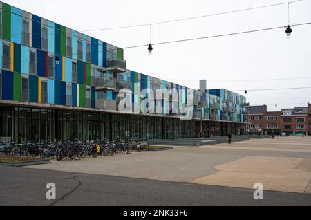 Kessel-Lo, Flemish Brabant, Belgium - Feb 11 2023 - Colorful facades of student houses with a cyclist parking Stock Photo