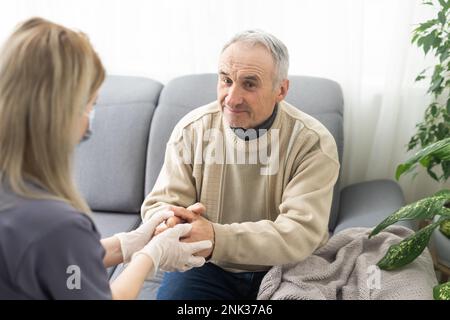 Portrait of mature female psychiatrist interviewing handicapped senior man during therapy session, copy space. Stock Photo