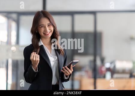 Young happy lucky Business woman feeling excited winner looking at cellphone using mobile phone winning online, receiving great news or sms offer Stock Photo