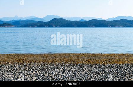 Pebble beach at sunrise, Rebecca Spit Marine Provincial Park, Quadra Island, Vancouver Island, BC, Canada. Stock Photo