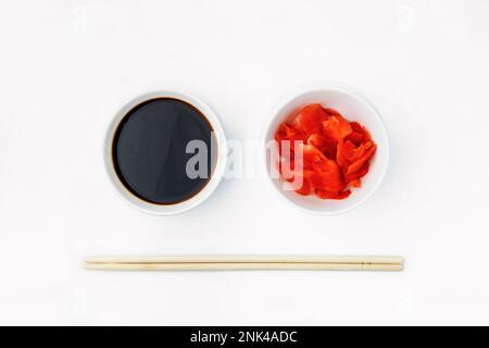 Funny face image of emoticon from soy sauce, pickled ginger and chopsticks, isolated on a white background. Creative oriental cuisine, restaurant conc Stock Photo