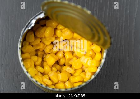 Close-up view from above of corn in a tin can on a dark table Stock Photo