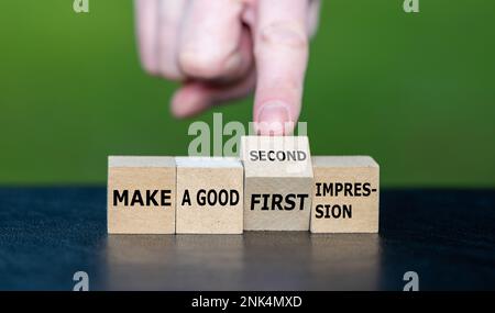 Symbol for a second chance. Hand turns wooden cube and changes the expression 'make a good first impression' to 'make a good second impression'. Stock Photo
