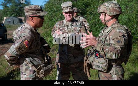 Col. Michael Flaherty, 37th Infantry Brigade Combat Team commander (right), informs Lt. Gen. Antonio A. Aguto Jr., 1st Army commander (left), and Brig. Gen Thomas E. Moore II, Ohio assistant general for the Army, about the ongoing training exercises during Operation Northern Strike at Camp Grayling, Mich., Aug. 11, 2022. Northern Strike is designed to challenge training audiences with multiple forms of convergence that advance interoperability across multicomponent, multinational and interagency partners. Stock Photo