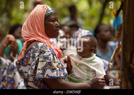 Agboville, Ivory Coast. 23rd Feb, 2023. A harvest worker sits with her child on a cocoa plantation. Federal Minister of Labor Heil and Federal Minister for Economic Cooperation and Development Schulze visit Ghana and Côte d'Ivoire. Credit: Christophe Gateau/dpa/Alamy Live News Stock Photo