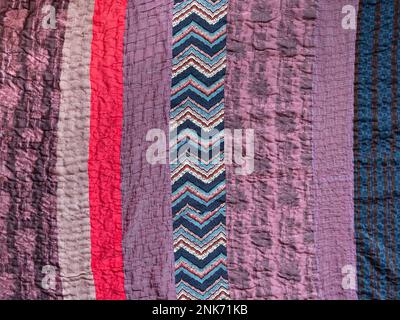 textile background - hand stitched patchwork cloth from various fabric stripes Stock Photo