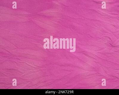 textile background - crushed silk fabric dyed in purple with tie-dye stains at home Stock Photo