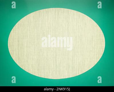 Mocap, oval vignette of a textured gray-green fabric on a dark green background. Space for text. Stock Photo
