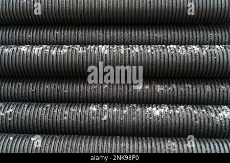 Texture of black corrugated pipes. Industrial backgrounds and textures. Stock Photo