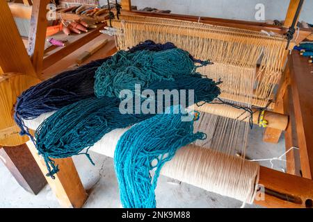 Skeins of yarn dyed with natural dyes on a wooden loom in a family weaving workshop in San Miguel del Valle, Oaxaca, Mexico. Stock Photo