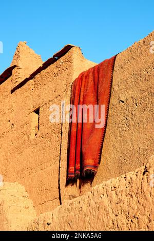 Drying carpet on the earthen walls of the house, Morocco Stock Photo
