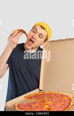 Young man eating pizza with a box in his hands Stock Photo