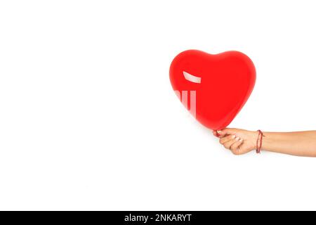 Woman hand holding a heart shape purple balloon on a white background with copy space Stock Photo