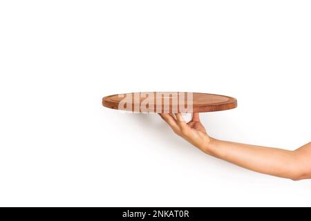 Woman hand holding a brown round wooden plate on a white background with copy space Stock Photo
