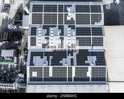 Big factory with solar panels installed on top, aerial top down view Stock Photo