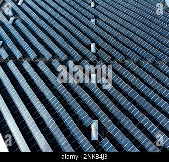 Large solar panel array stacked farm on a distribution warehouse building top down aerial view Stock Photo