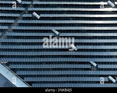 Large solar panel array stacked farm on a distribution warehouse building top down aerial view Stock Photo