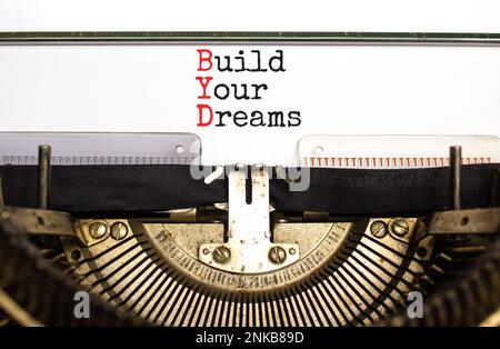 BYD build your dreams symbol. Concept words BYD build your dreams typed on retro old typewriter on a beautiful white paper background. Business and BY Stock Photo