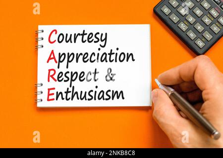 CARE symbol. Concept words CARE courtesy appreciation respect and enthusiasm on white note on beautiful orange background. Business CARE courtesy appr Stock Photo