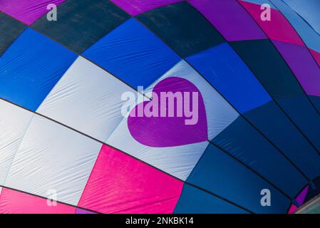 Bold and garish colors and patterns of hot air balloons. Stock Photo
