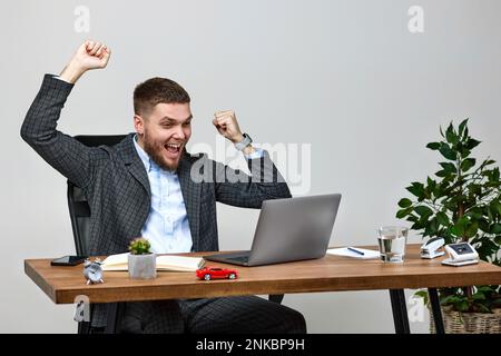 man sitting on chair at table and resting, using laptop Stock Photo