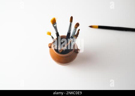 Top view earthenware jar with brushes isolated on a white background Stock Photo