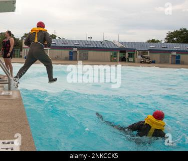 Two members of the 127th Air Refueling Group, Selfridge Air National Guard Base, Michigan, simulate evacuating a downed aircraft during water survival training at a local water park on August 13, 2022. Part of a routine skill certification, the survival, evasion, resistance and escape training gave KC-135 Stratotanker aircrew and A-10 Thunderbolt II pilots practice on how to survive if their planes crash over a large body of water. Stock Photo