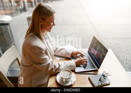Woman freelance programer working on laptop while sitting in cafe. Data done right Stock Photo