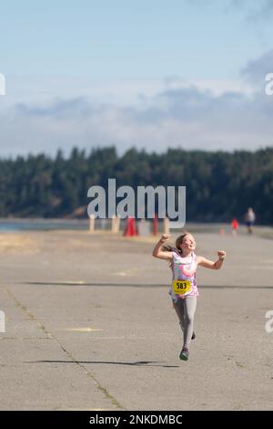 Alli Applewhite crosses the 1-mile finish line as the second female winner  at Naval Magazine Indian Island during the Deer Run in Port Hadlock,  Washington, August 13, 2022. About 150 runners and walkers participated in  this year's 5k and 1-mile Deer Run ...