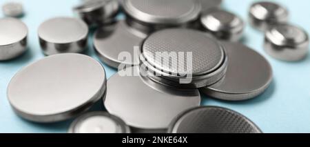 Lithium cell batteries on light blue background, closeup Stock Photo