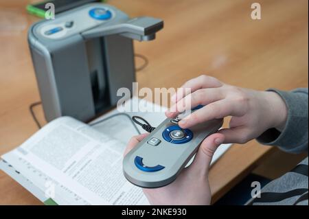 A visually impaired man uses a scanning and reading machine. Stock Photo