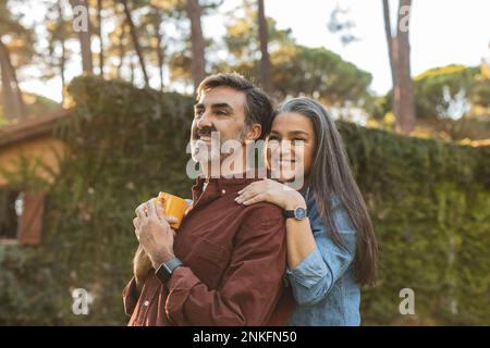 Happy affectionate mature couple standing outside building Stock Photo