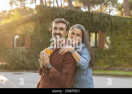 Happy affectionate mature couple standing outside building Stock Photo