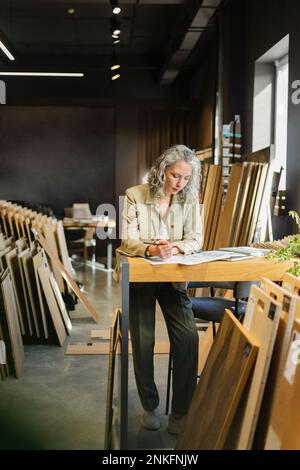 Female architect working at table in office Stock Photo