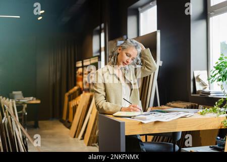 Female architect working at table in office Stock Photo